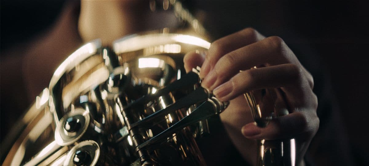 Closeup view of female hand playing Yamaha French Horns