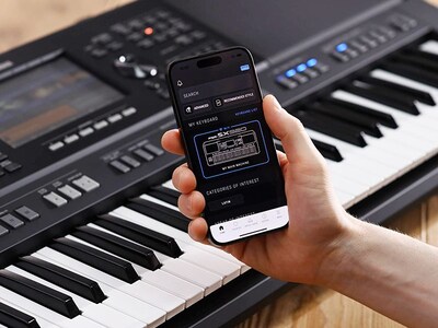 Yamaha Arrange Workstation PSR-SX920 and a hand holding a smartphone with the Yamaha official app “E…