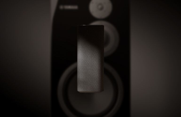 True X speaker floating on a blurry sub-woofer background