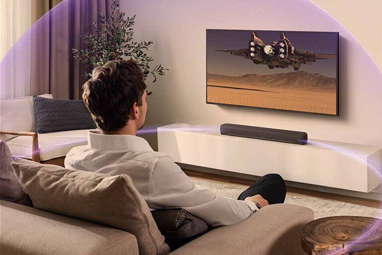 Person watching TV with B200A and immersive sound effects