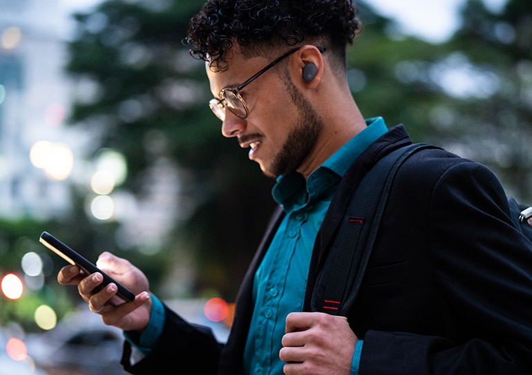 image of a man wearing yamaha black TW-E5B True Wireless Earbuds and looking at the cell phone 
