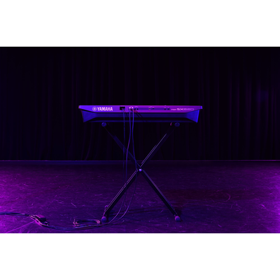 A keyboard on a stand under stage lighting