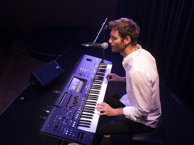 Image of a person singing and playing the yamaha keyboard