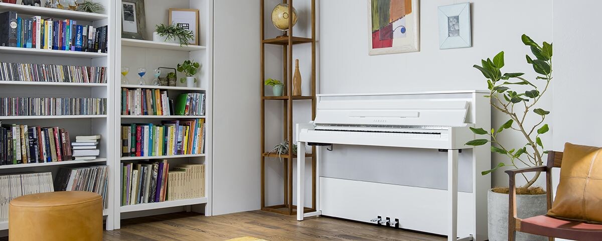 A white AvantGrand NU1X piano in a nice cozy livingroo.