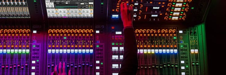 Close up image showing a person hand on Yamaha mixer