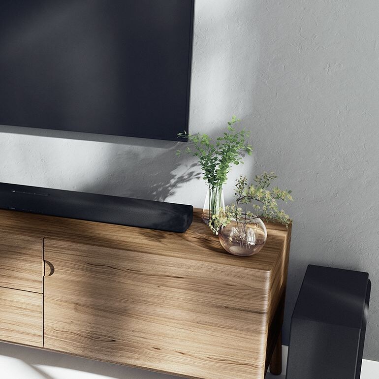 True X sound bar on top a shelf below a TV