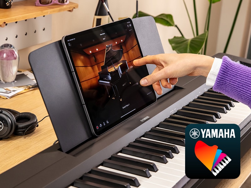 The Yamaha “Smart Pianist” app icon, together with a tablet placed on the music stand of the P-143