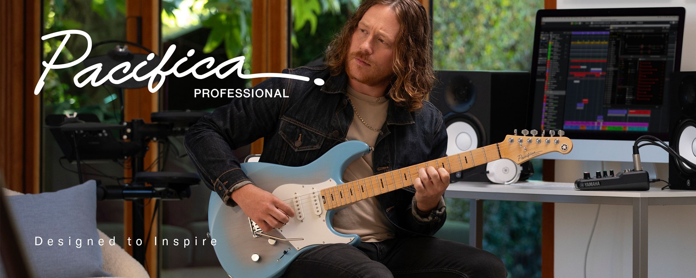 Pacifica professional logo & designed to inspire text. Male in home studio playing Beach Blue Burst.
