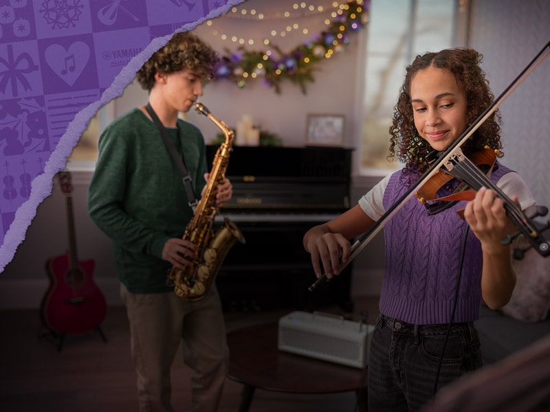 Teenager boy smiling playing the saxophone and the teenager girl smiling playing the violin 