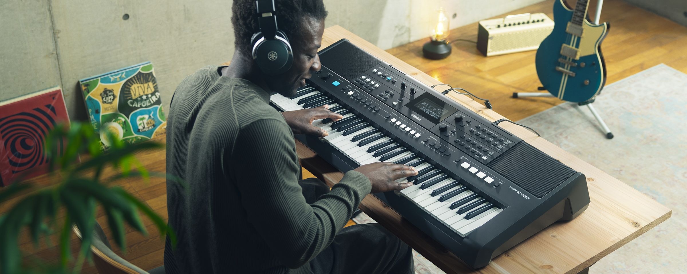 A person playing Yamaha Portable Keyboard PSR-E483 with headphones