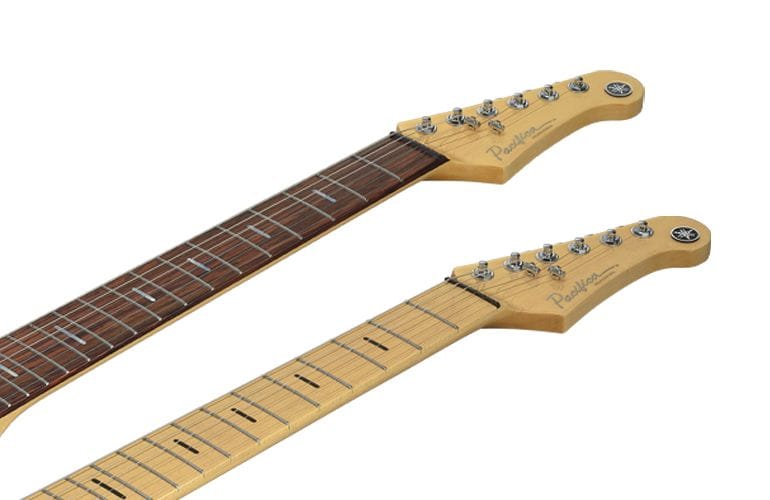 Close-up of Pacifica Professional rosewood and maple fingerboards with headstocks. Grey background.
