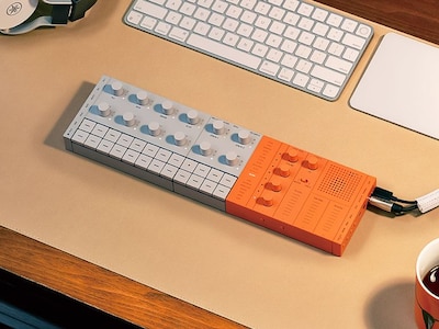 SEQTRAK orange placed on a desk and plugged into a computer.