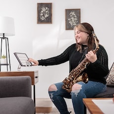 image of a female holding Yamaha Saxohphone