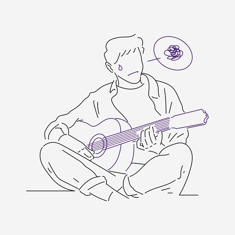 A man having difficulty practicing the guitar