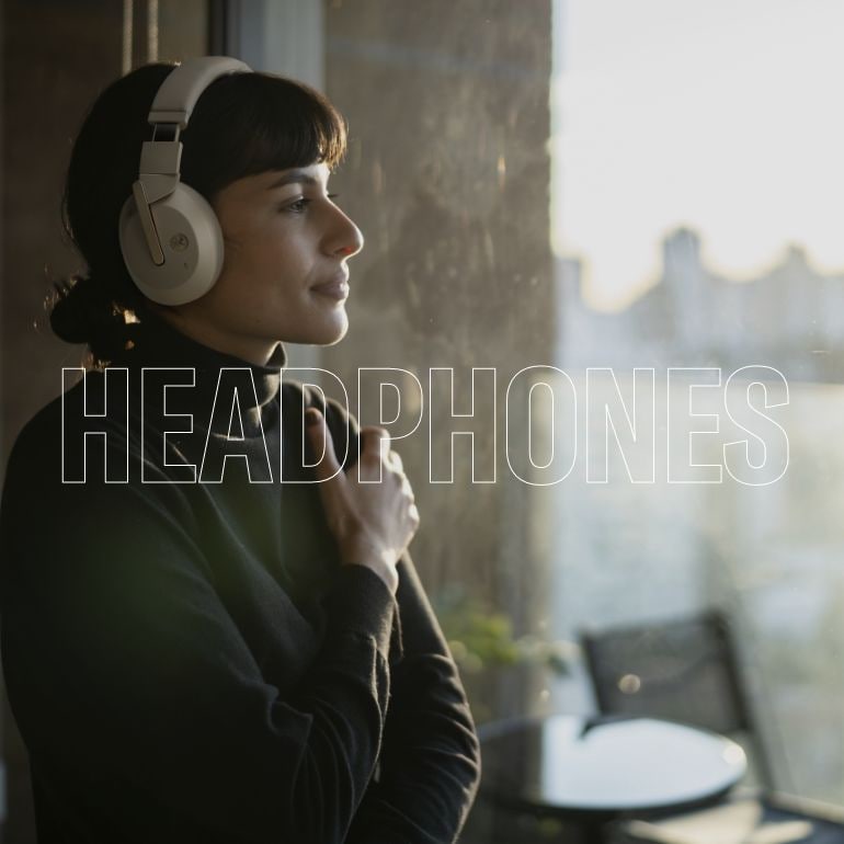 Lifestyle image showing a woman wearing Yamaha YH-E700B beige color headphone