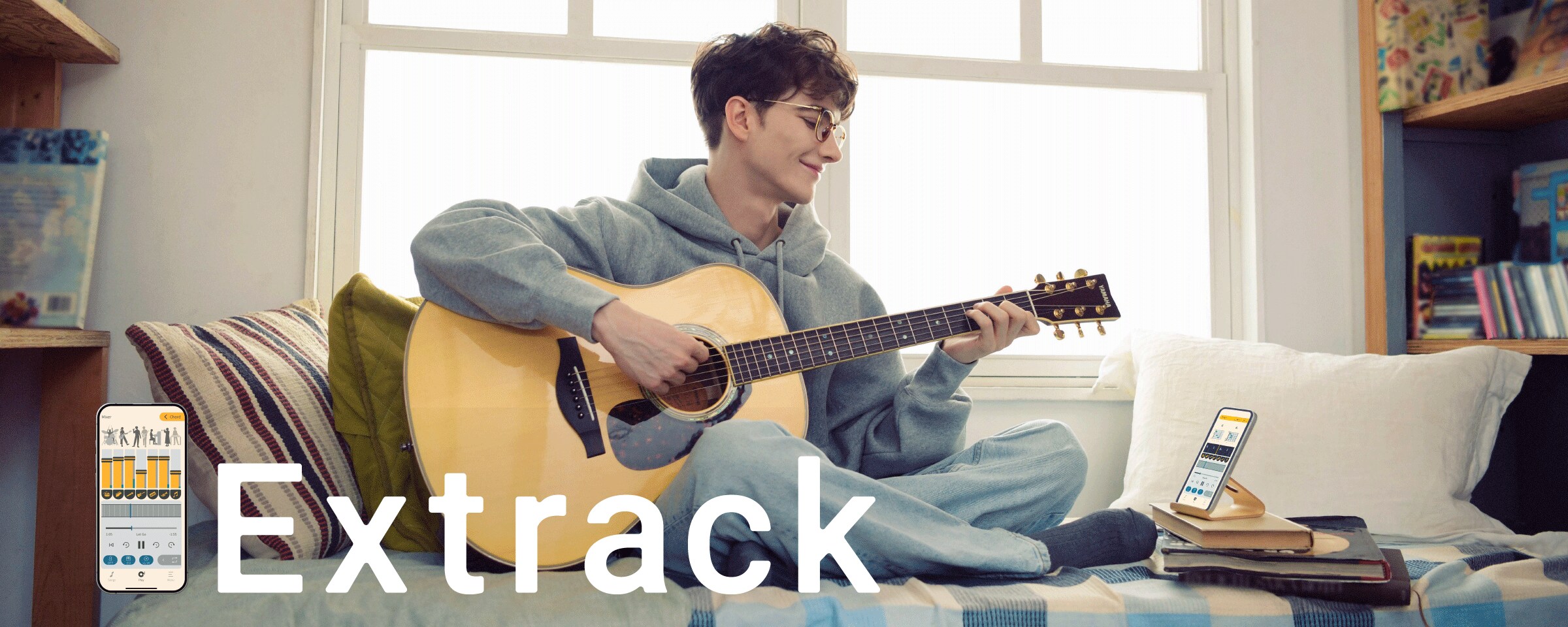 A man enjoys practicing the guitar while sitting on the sofa and playing along with the Extrack music practice app