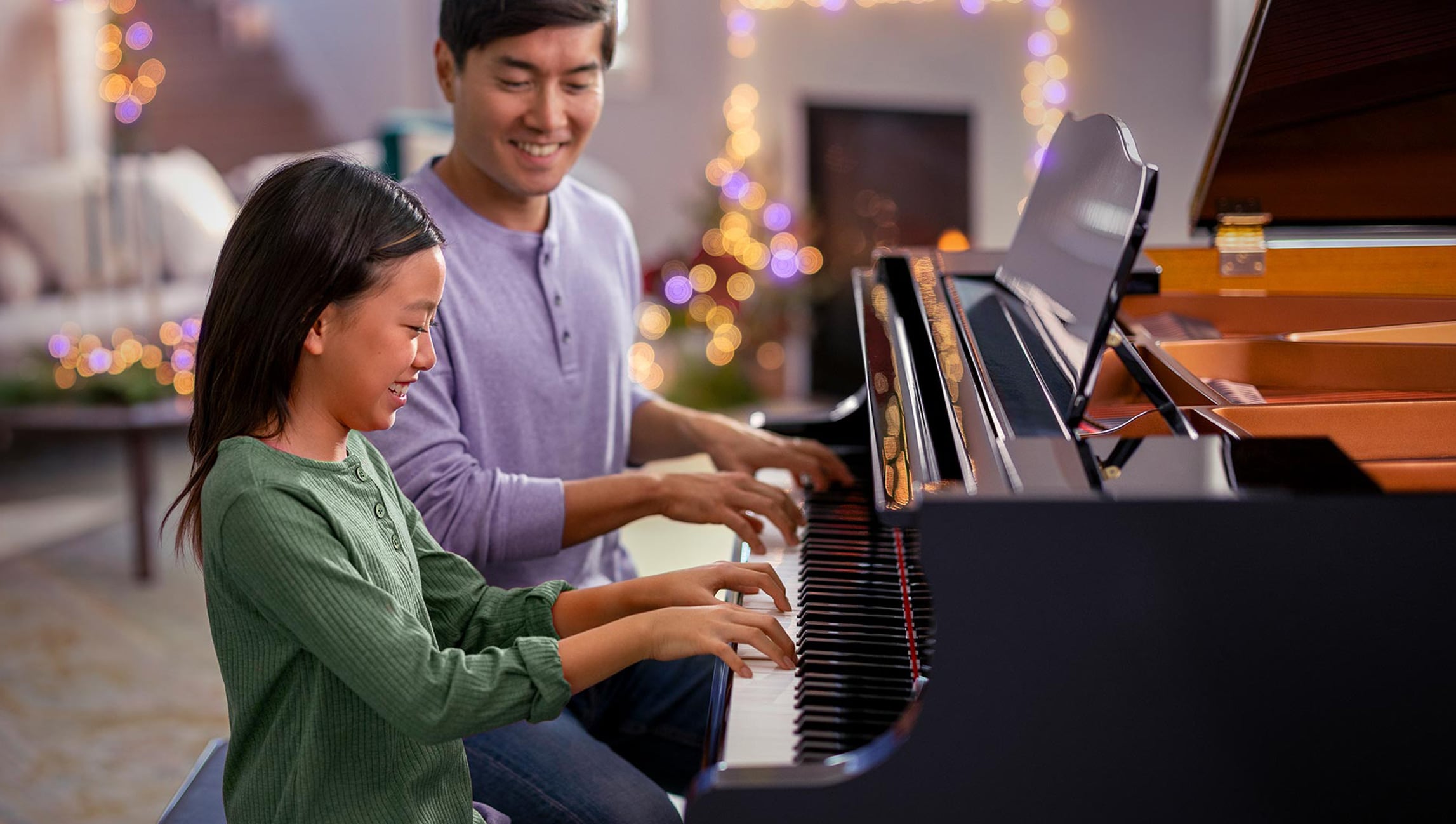 happy father with daughter playing the piano 