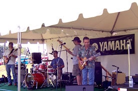 Band playing on stage in front of Yamaha banner