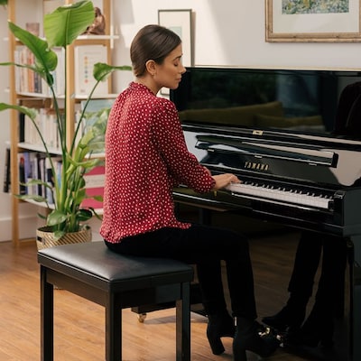 Image of a woman playing acoustic piano