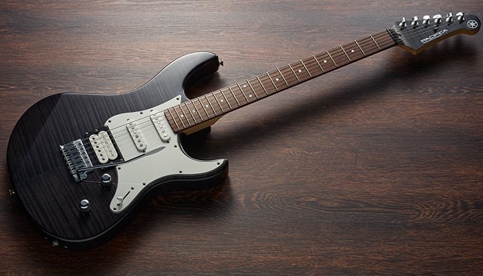 Translucent Black Pacifica 200 Series with rosewood fingerboard laying on ground.